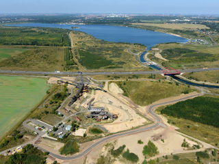 Bergbauzeugen und touristische Zukunft des ehemaligen Braunkohlentagebaues Espenhain auf einen Blick: Im Vordergrund der Bergbau-Technik-Park und die BAB 38, dahinter der Markkleeberger See und die Stadt Leipzig (Foto: P. Radke 09/2013, LMBV; aus EDGG Nr. 251/2014)